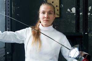 Female fencer poses with foil